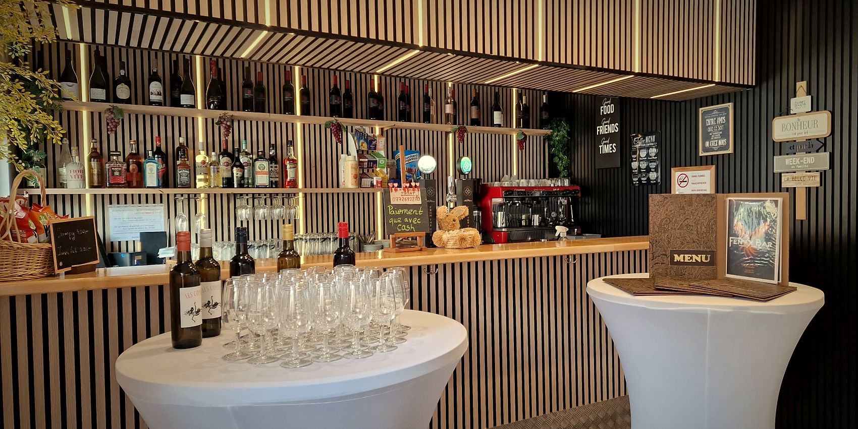Le comptoir du Fenyx éclairé, avec les bouteilles et les verres à vin