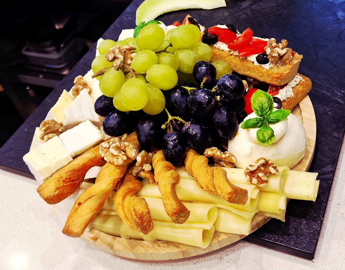 Plateau de fromages avec raisins, noix, burrata et tartines