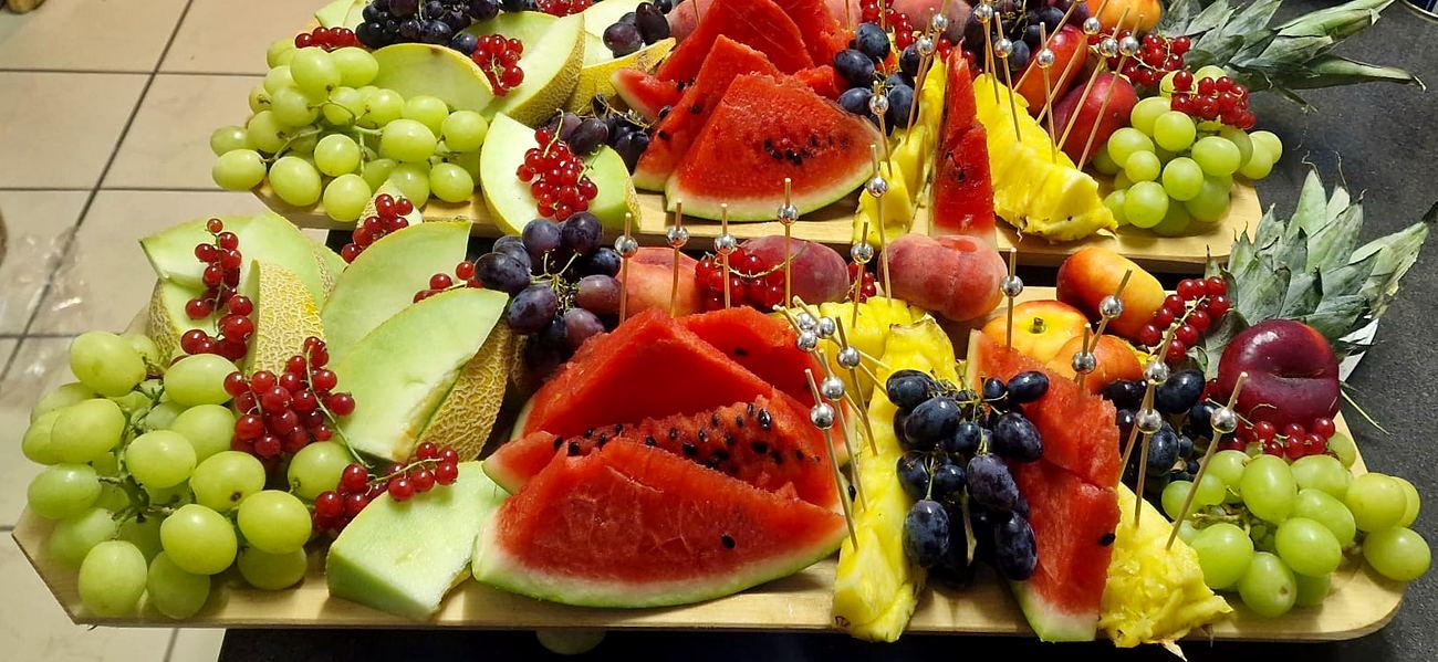 Deux planches de fruits frais : pastèque, melon, ananas, raisins et groseilles