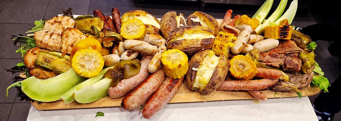 Plateau de saucisses, pommes de terre au four et maïs grillé